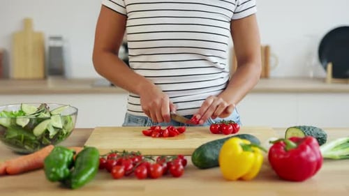 Woman Cuts Cherry Tomatoes in Bright Kitchen