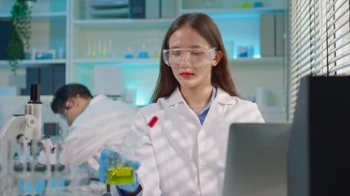 Asian female scientist working in the biotechnology research laboratory.