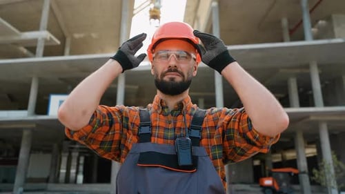 Construction Worker Putting on Hard Hat and Smiling
