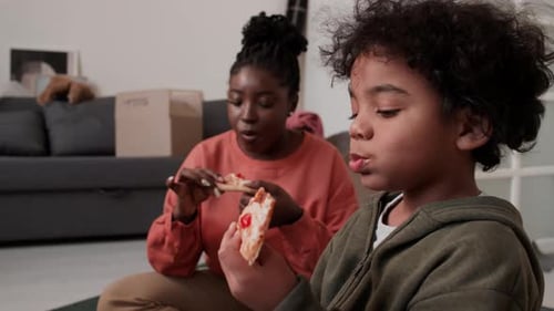 Mother and Child Enjoying Pizza Together at Home
