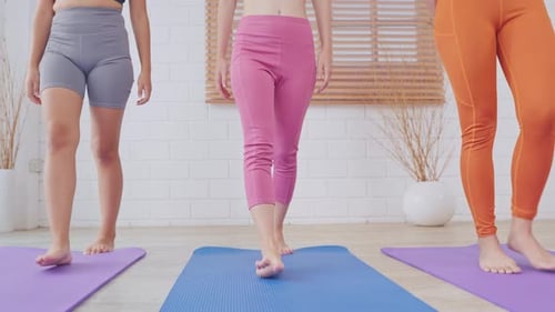 Close up of sportswoman roll out exercise mat in the fitness studio.