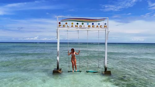 Woman on Swing in Tropical Beach Paradise