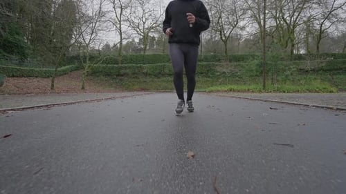 Runner jogging in slow motion on park road