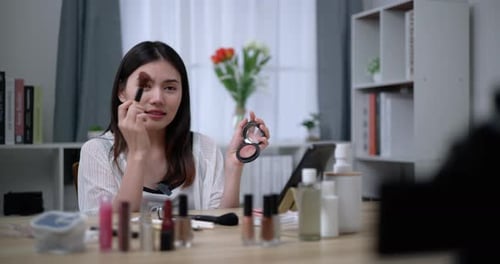 Hermosa bloguera asiática está mostrando cómo maquillar y usar cosméticos