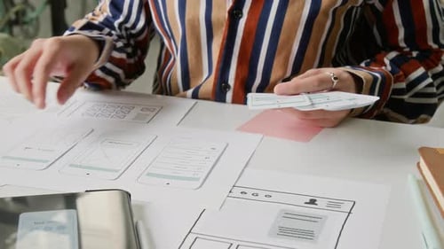 Woman Designs Mobile App Interface on White Table