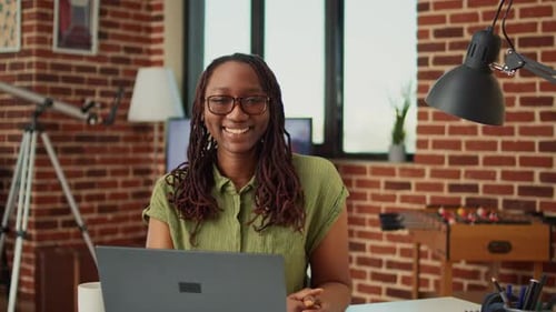 African American Woman Writing Information on Laptop