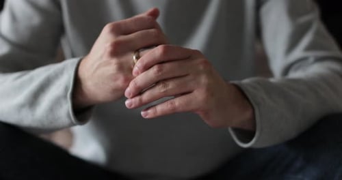 Mann wackelt mit seinem Ehering an seinem Finger Mann leidet unter emotionalem Schmerz, Verzweiflung und Einsamkeit