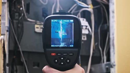 Technician Inspecting Electrical Panel with Thermal Imaging Camera
