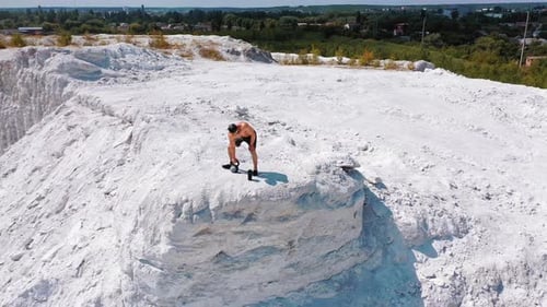 Brutal strong bodybuilder pumping up muscles. Bodybuilding and outdoor sports concept. Aerial view.