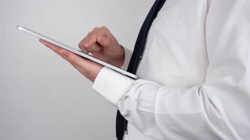 Man in Shirt and Tie Using a Tablet