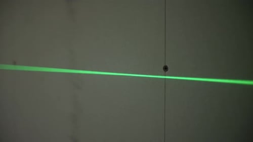 Green Laser Level Line on Wall with Marked Drill Hole