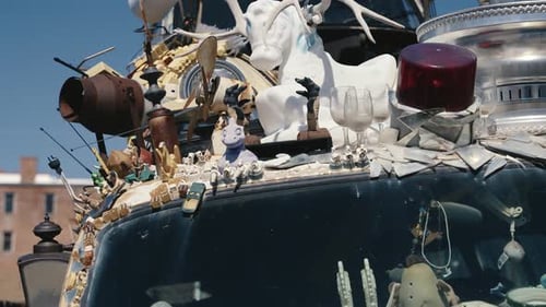 Eccentric Vehicle Topped with Objects in Urban Setting