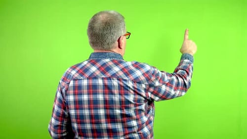 Rear View of Senior Man Which Touching Sliding and Swiping on Green Wall