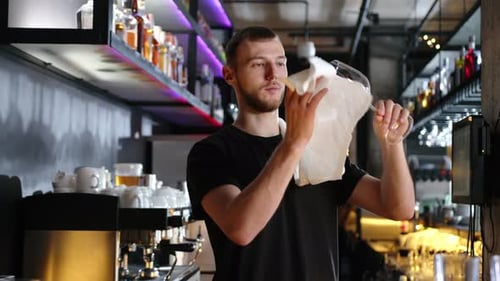 Young Adult Cleans a Wine Glass in Bar