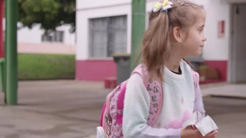 Smiling Schoolgirl with Backpack Walking on Street