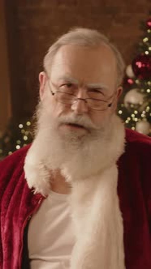 Man Dressed up as Santa Admiring Appearance while Posing for Camera