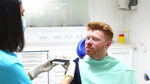 Dentist Matching Tooth Color for Man in Office
