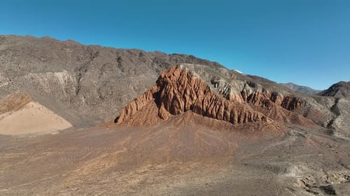 Unique rugged red rock formation in a vast arid mountain landscape