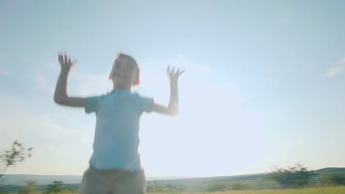 Joyful Boy Running Freely in Open Field on a Sunny Summer Day