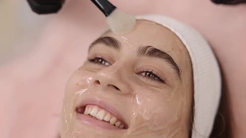 Woman Receiving Facial Mask Treatment at Spa