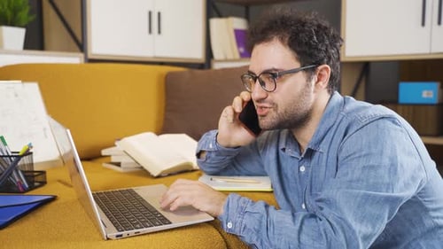 Young Adult Using Laptop and Smartphone on Couch