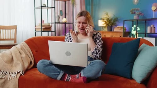 Frustrated Woman Talking on Phone with Laptop