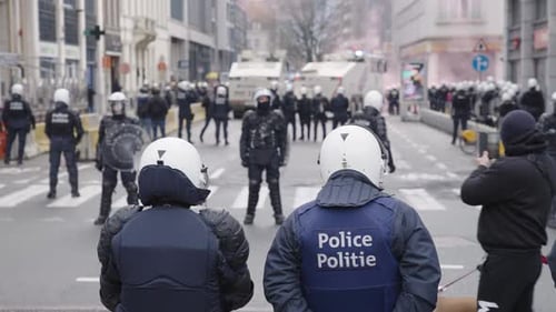 Shameless male person and his dog filming riot police officers, water canon and riots in the city