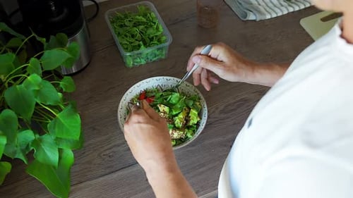 Person Preparing Healthy Salad in Kitchen