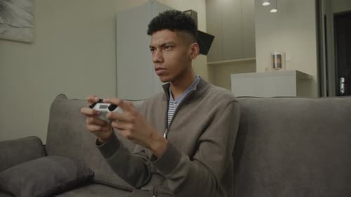 Young Adult Gaming with Controller on Couch