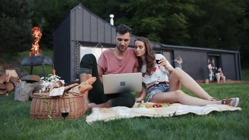 Young Couple Relaxing with Laptop at Cabin