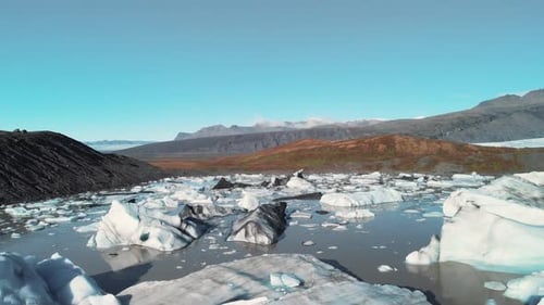Icebergs on a volcanic shore of Skaftafell glacier lake in Iceland.
