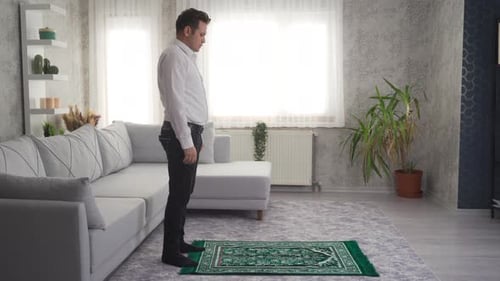 Man Kneeling and Praying on Rug Indoors