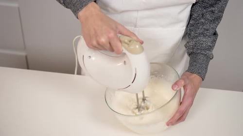 Boy Making Dough and Cake with Electric Mixer Machine in Kitchen Close Up White Airy Cream Mixed in