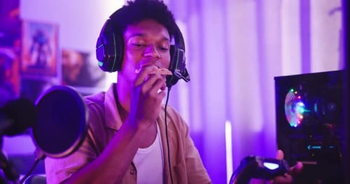 Young Adult Eating Pizza While Gaming at Home