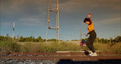 Frau läuft und spielt auf toten Gleisen Verlassene Eisenbahn