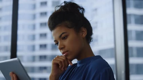 Pensive Businesswoman Working Tablet Computer in Office. Thoughtful Business Woman Reading Informati