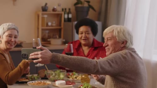 Seniors Enjoying Meal Together and Taking Selfie