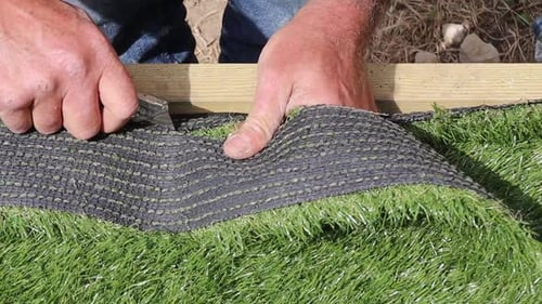 Trimming artificial grass in close up