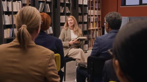 Audience Raising Their Hands After Listening to Book Author in Library
