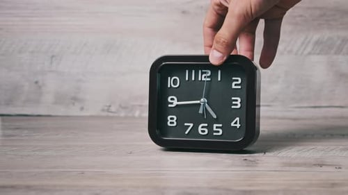 Male Hand Puts an Arrow Mechanical Watch on a Wooden Table