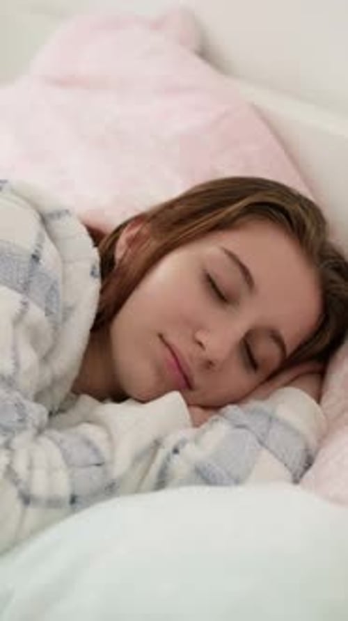 Junges Mädchen schläft süß im Bett im Pyjama