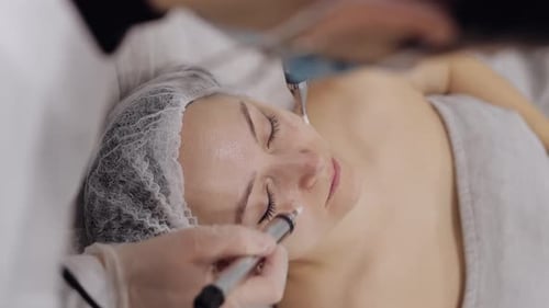 Beautician Doctor Makes Woman Micro Currents Face Therapy Using Electrical Impulses in Spa Salon
