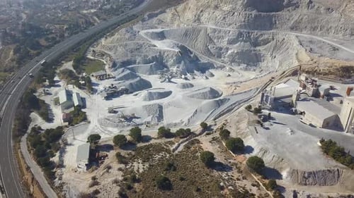 Aerial revealing view of a big quarry in a mountain.