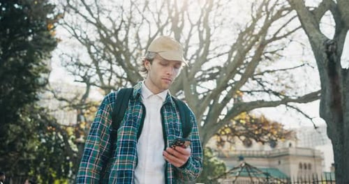 Young Man with Phone in City Park Setting