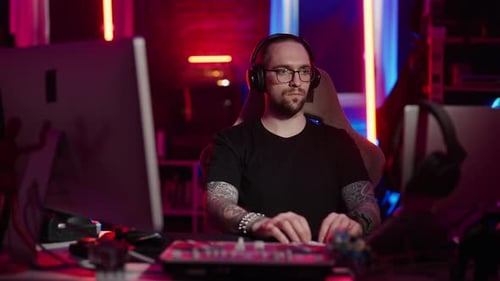 Man wearing headphones works on mixing board