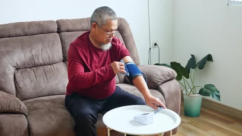 Senior Man Checks Blood Pressure at Home