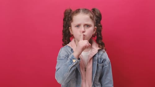 Girl with Curly Hair Gives Shush Gesture