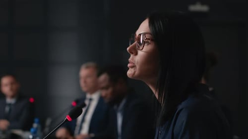 Speech Of Political Speaker At Meeting Room Of Modern Business Center. Adult Woman In Suit Explai...