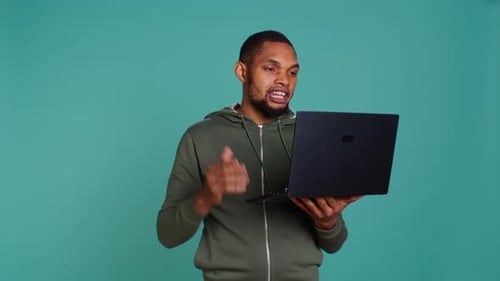 Man Talking to Laptop in Studio Setting