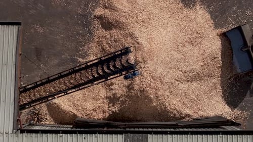 Holzspäne, die mit einem Bandförderer im Sägewerk zu einer Halde transportiert werden. - Luftaufnahme